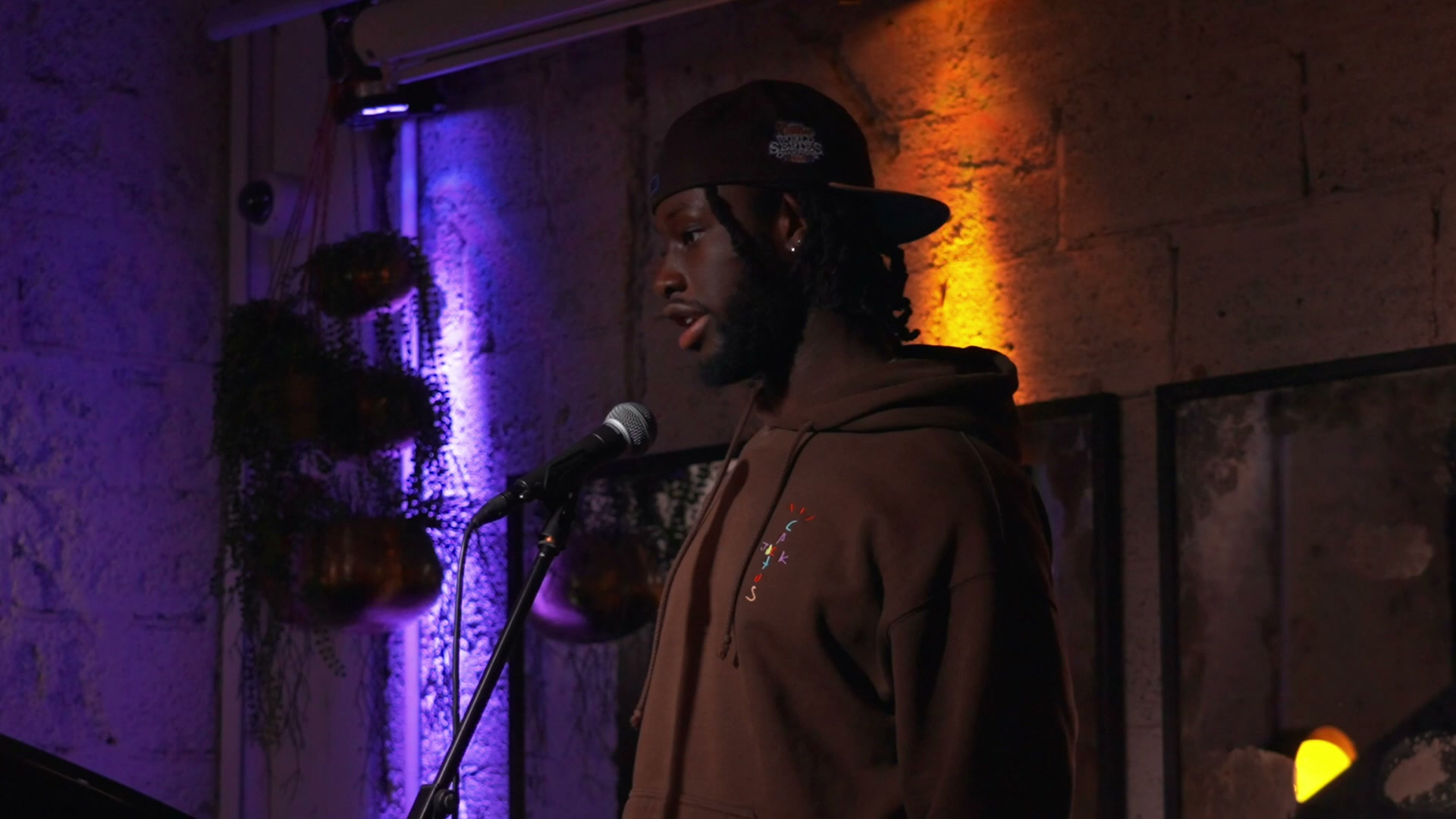 KAYZ performing at Writers Block London under purple and amber light