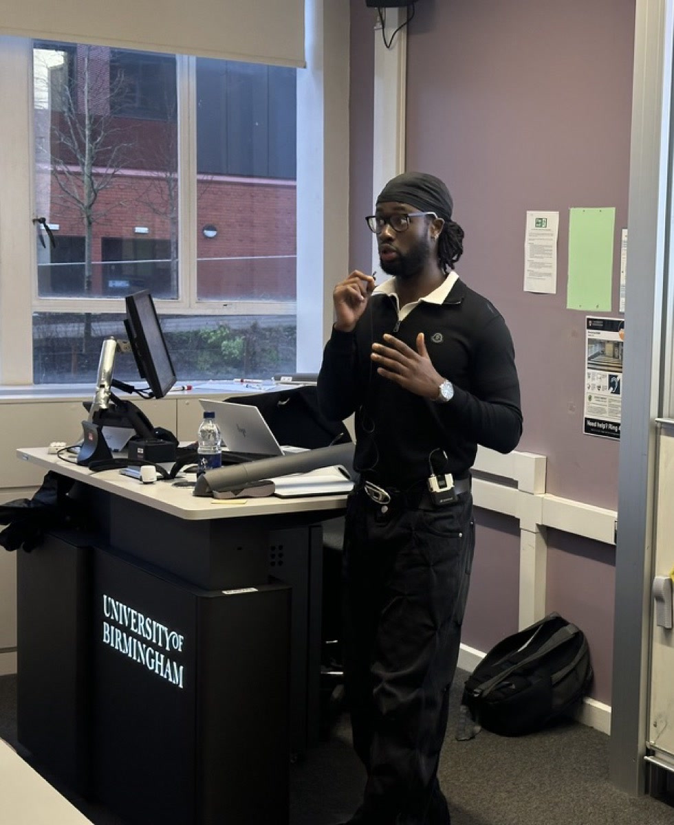 KAYZ delivering a seminar at a University of Birmingham lectern